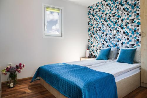 弗瓦迪斯瓦沃沃Domki Bungalow Stella Resort & SPA的一间卧室配有一张带蓝色毯子的床