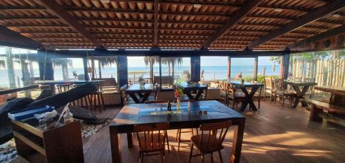 马拉塔伊济斯Hospedaria Rosa dos Ventos的一间带桌椅的海景餐厅