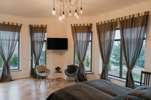 马鲁佩Valet Apartment的卧室设有窗户和1张床及椅子