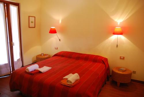 特雷梅佐赛维罗加洛住宿加早餐旅馆的一间卧室配有红色的床和2条毛巾