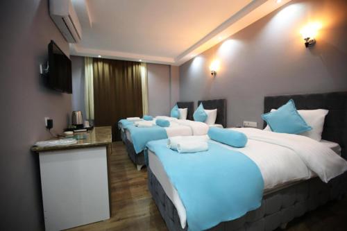 MahmutluGrand Atakum Boutıque Hotel的酒店客房 - 带4张带蓝色枕头的床