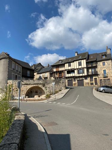 Saint-Côme-dʼOltAu Pont d’Olt的前方有道路的古老石头建筑