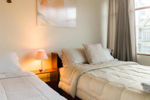 拉巴斯Bright & Comfy Guest House in La Paz的一间卧室设有两张靠窗的床。