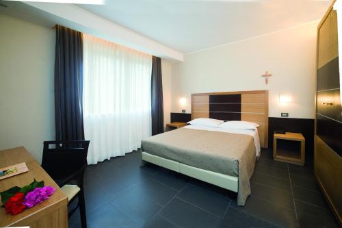 圣乔瓦尼·罗通多维托瑞亚酒店的配有一张床和一张书桌的酒店客房