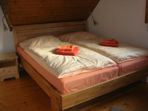 特尔乔夫Drevenica pod smrekom的床上有两个橙色枕头