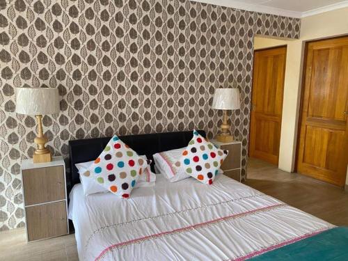 约翰内斯堡Elegant84的一间卧室配有一张带波卡圆点枕头的床。