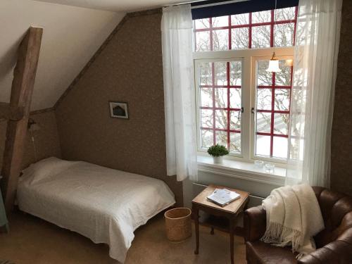 迪韦德Medstugans vandrarhem的卧室配有床、椅子和窗户。
