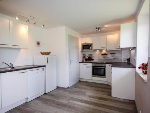 奥西阿赫Holiday Home Sonnhaus by Interhome的白色的厨房配有白色橱柜和电器