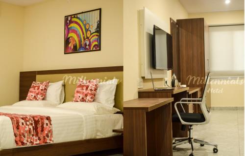 班加罗尔PPH Living Millennials Jigani的一间卧室配有一张床、一张桌子和一台电脑