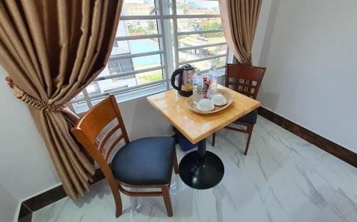 波贝Pheng Chenda Hotel的窗户客房内的小桌子和椅子