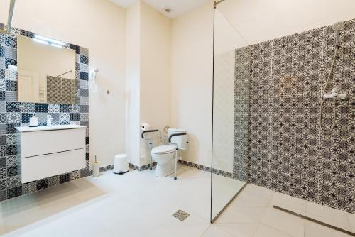 图尔达Pensiunea Salina Gymnasium的一间带卫生间和玻璃淋浴间的浴室