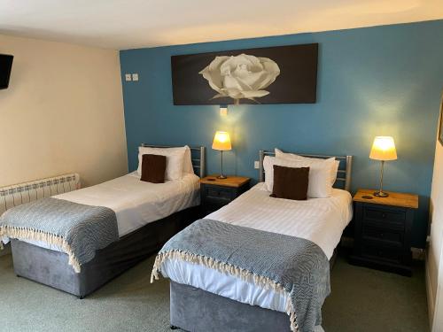 霍伊斯枫丹酒店的蓝色墙壁客房的两张床