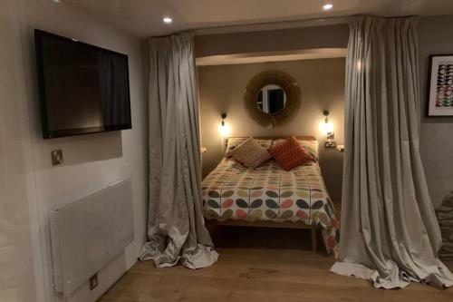 奥斯威斯Wilderness Lodge的一间卧室配有一张带窗帘的床和电视。