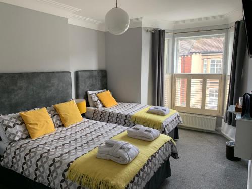 雷德卡Armada Guesthouse的配有两张带黄色枕头的床铺