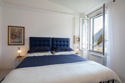 蒙特罗索阿尔马雷Come Eravamo的一间卧室配有一张大床、蓝色床头板和窗户
