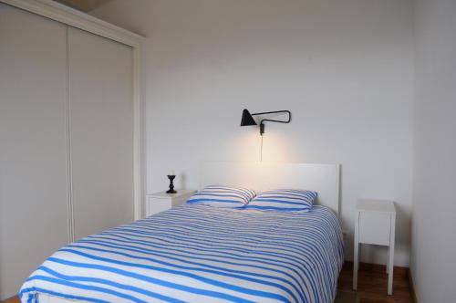 Calheta de NesquimCasa do Baleeiro的一间卧室配有一张蓝色和白色条纹的床