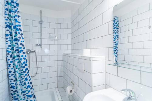 杜塞尔多夫Apartment 120 qm -3 Schlafzimmer-2 Bäder- für 8 Gäste的带淋浴和卫生间的白色瓷砖浴室