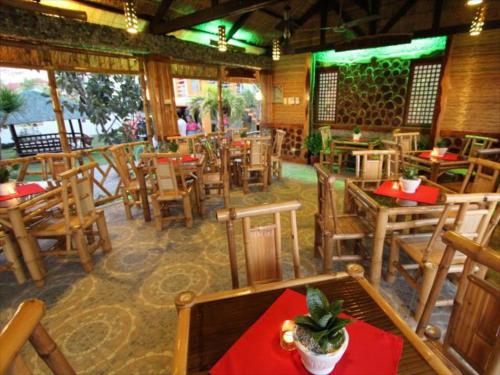 圣胡安P&M Final Option Beach Resort的一间空餐厅,配有木桌和椅子