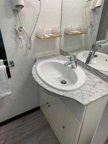 塔布Everhotel de Tarbes-Ibos的白色的浴室设有水槽和镜子
