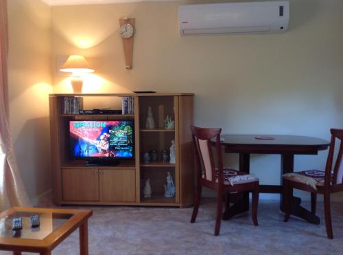 堪培拉库克度假屋的客厅配有电视和桌椅