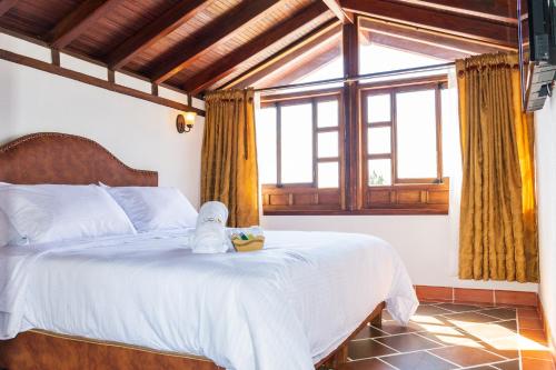 莱瓦镇HOTEL ENCANTO COLONIAL的卧室里设有一张床,上面有一只动物