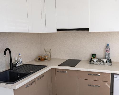 古尔贝内Central Park studio的厨房配有白色橱柜、水槽和炉灶。