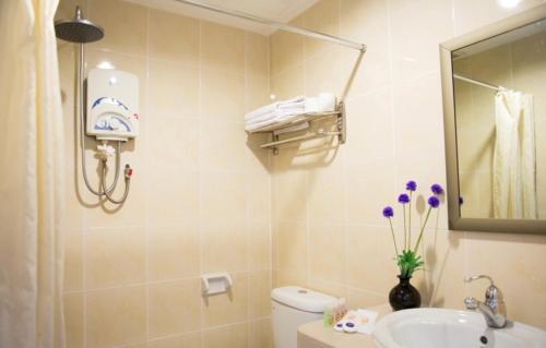 新山紫藤酒店的一间带水槽、卫生间和镜子的浴室