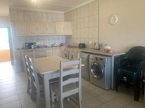 谢丽海滩Holiday unit 37 Eden dunes的厨房配有桌子和洗衣机。