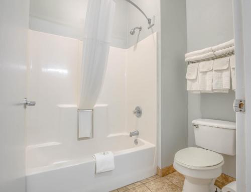 格尔夫海岸Quality Inn的白色的浴室设有浴缸和卫生间。
