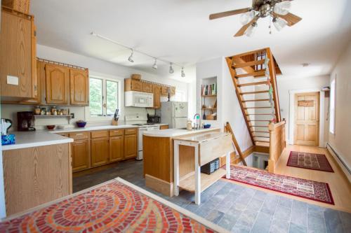 北伍德斯托克峡谷旅舍的一个带木制橱柜的厨房和一个楼梯