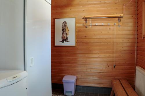 阿卡斯洛姆波罗TaloYlläs, Huonemajoitus的浴室设有木墙,并画有一只狗的照片