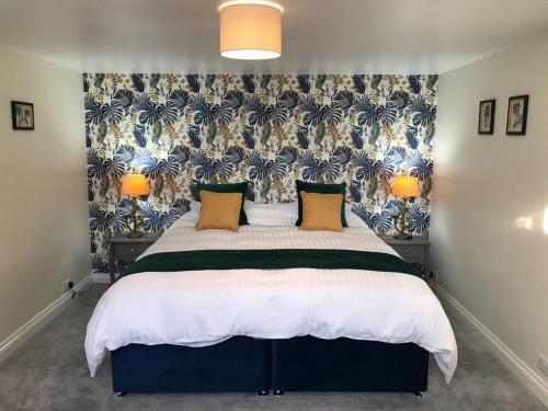 滨海韦斯顿Hill Cottage的一间卧室配有一张带花卉壁纸的大床
