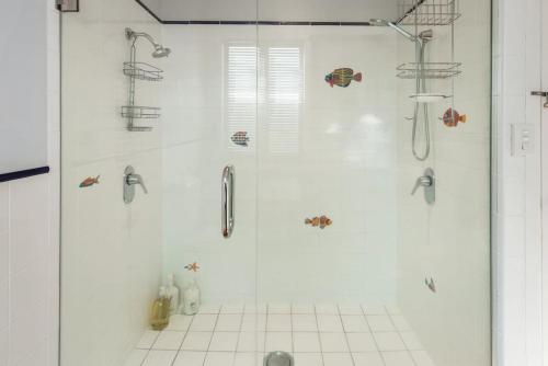 惠灵顿Waterfront 2-bed cottage, Karaka Bays的浴室里设有玻璃门淋浴