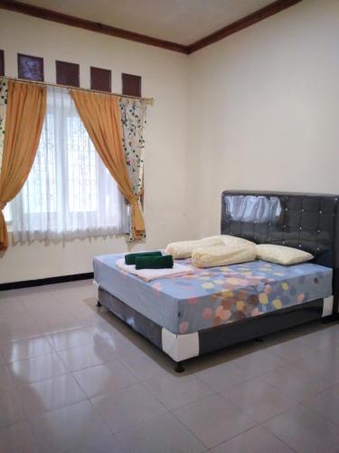 TanjungkarangRUMAH PAKSI HOMESTAY的一间设有床铺的卧室,位于带窗户的房间内