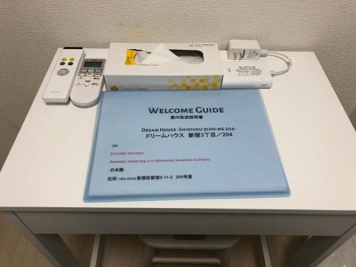 东京Fact Dream House 新宿三丁目徒歩3分色々揃うワンルーム的一张带视频游戏控制器的桌子上的欢迎信封
