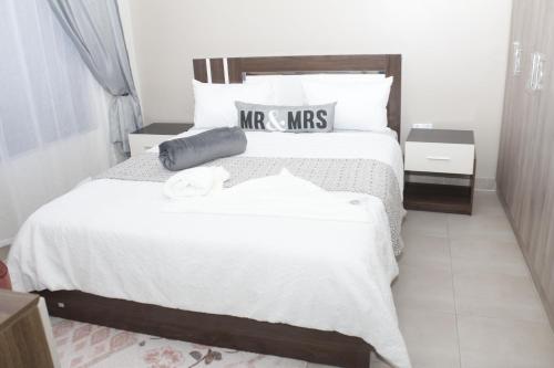 KitweRoyal Luxury Hotels and Apartments的卧室配有一张带白色床单和枕头的大床。