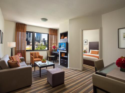 墨尔本Urban Apartments Melbourne on Elizabeth的客厅配有沙发和1张床