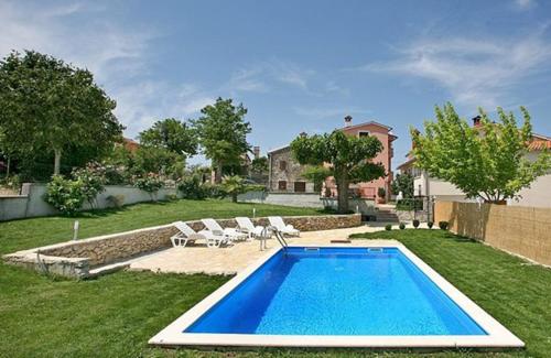 莫托文瓦伦蒂诺宾馆的一个带椅子的庭院和房子的游泳池