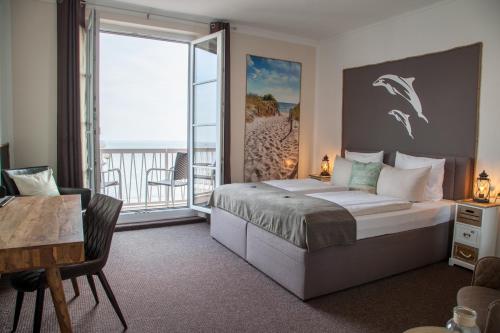 威廉港AKZENT Strandhotels Seestern, Delphin & Lachs的一间带大床的卧室和一个阳台