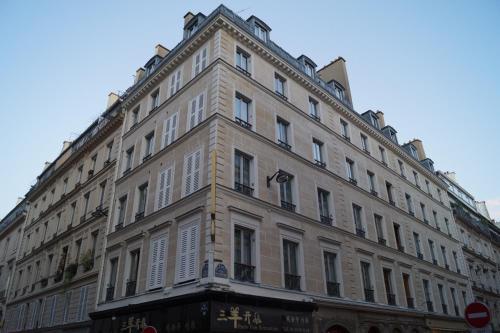 巴黎Hotel Havane Opera的一座白色的大建筑,有很多窗户