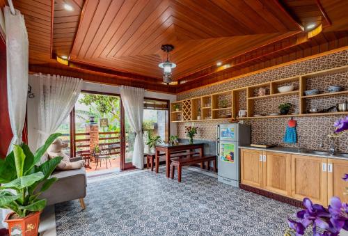会安Art Villa Hoi An的一间带木制天花板的厨房和一间餐厅