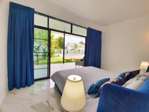 蔻立Villa SABAÏ的一间卧室设有一张床和一个大窗户