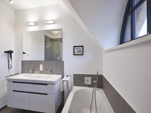 德兰斯克Reetland am Meer - Premium Reetdachvilla mit 3 Schlafzimmern, Sauna und Kamin F10的白色的浴室设有水槽和浴缸。