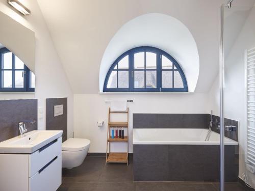 德兰斯克Reetland am Meer - Luxus Reetdachvilla mit 3 Schlafzimmern, Sauna und Kamin F12的阁楼浴室设有水槽和浴缸。