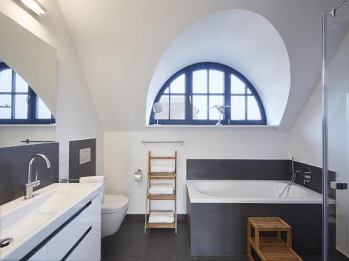 德兰斯克Reetland am Meer - Luxus Reetdachvilla mit 3 Schlafzimmern, Sauna und Kamin F08的阁楼浴室设有水槽和浴缸。
