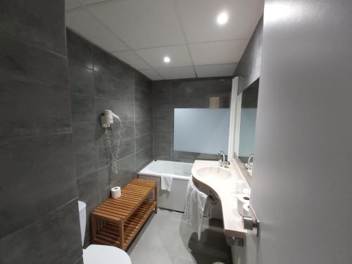 巴黎肯辛顿埃菲尔酒店的浴室配有盥洗盆、卫生间和浴缸。