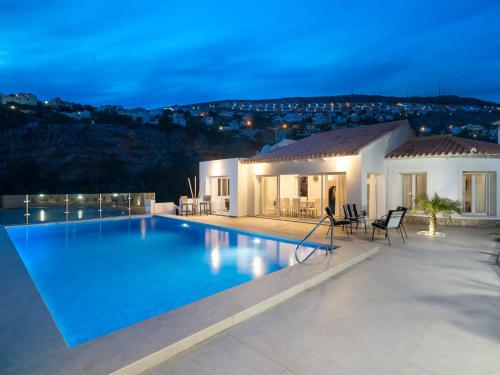 贝尼塔切利Holiday Home Vista al Mar by Interhome的一座别墅,在晚上设有大型游泳池