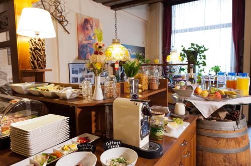 巴特塔茨曼斯多夫福余威尔斯旅馆的厨房配有餐桌和食物