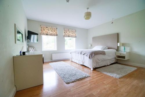 GalgormGlenburn Galgorm Bed & Breakfast的一间卧室配有一张床,铺有木地板