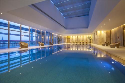 漳州漳州皇冠假日酒店的一座带大窗户的建筑中的游泳池